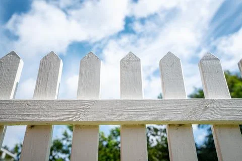 White picket fence under a blue sky Stock Photos