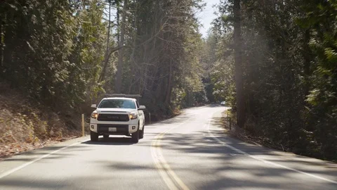 White Pickup Truck driving down coastal road in Northwest Washington State Stock Footage