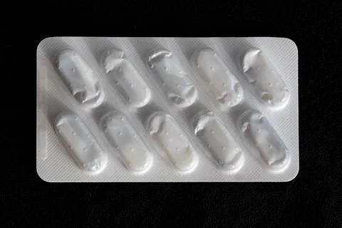 A white pill container with a black background Stock-Fotos