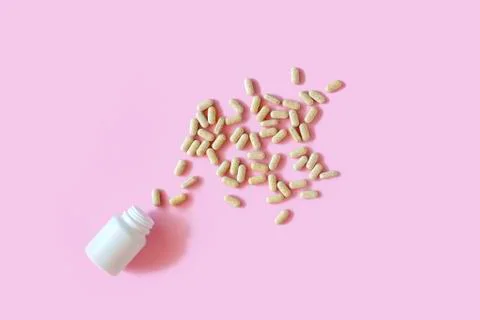 White pill packaging on pink background. Stock Photos