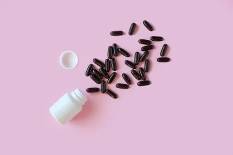 White pill packaging on pink background. Stock Photos