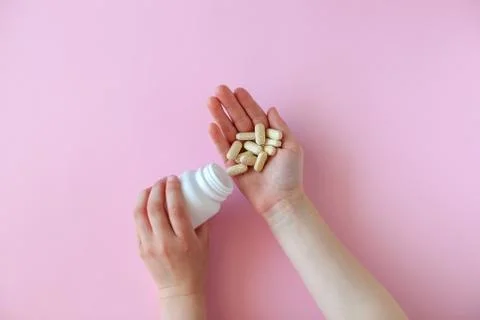 White pill packaging on pink background. Stock Photos