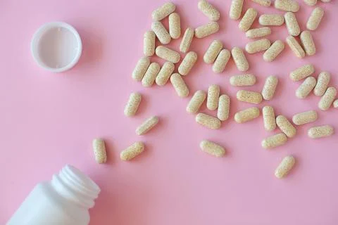 White pill packaging on pink background. Stock Photos