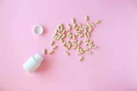 White pill packaging on pink background. Stock Photos