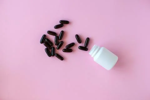 White pill packaging on pink background. Stock Photos