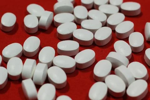 White pill with red background Stock Photos