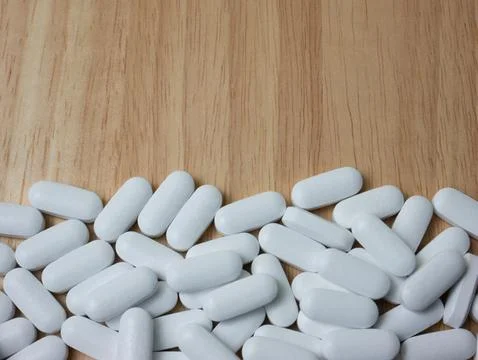 White pill on wood table for sci or medical concept Stock Photos