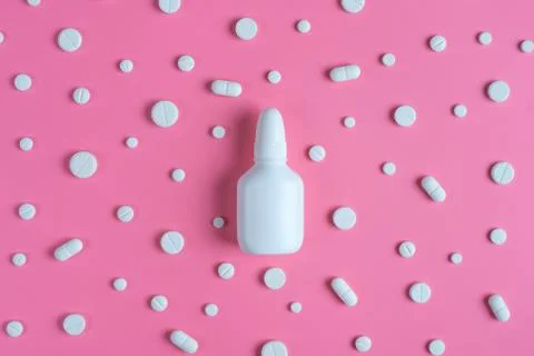 White pills and white bottle on pink background. Copy space for text Stock Photos
