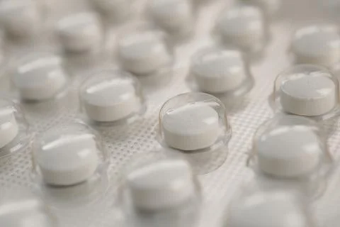 White pills arranged in bubble packaging on a flat surface Stock Photos