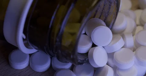 White pills in a fallen over brown bottle. Pharmaceuticals in a bottle Stock Footage 125959645