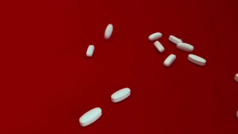 White pills falling on red background Video stock 170322071