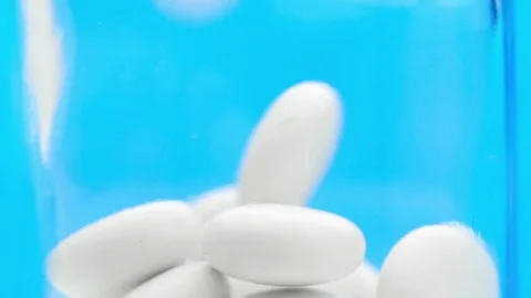 White pills falling in slow motion. Video stock 124325086