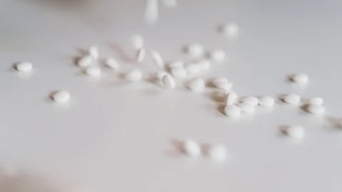 White pills falling on table Stock Footage 93621513