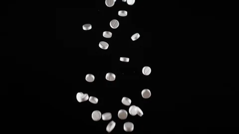 A white of pills fly up and fall. Side view. Slow motion Stock Footage 94387311