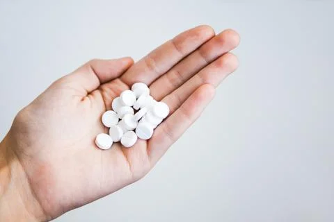 White pills in the hand, light background Stock Photos