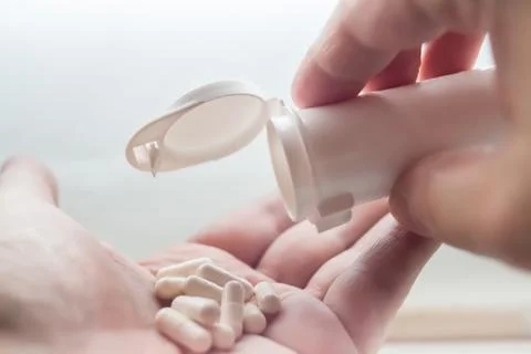 White pills on hand Stock Photos