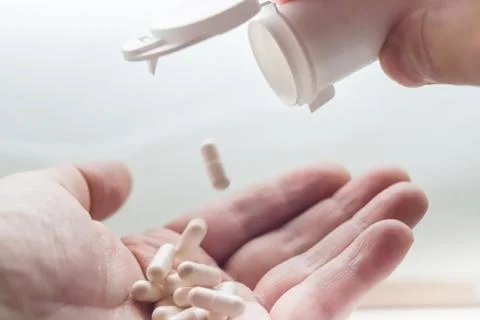 White pills on hand Stock Photos
