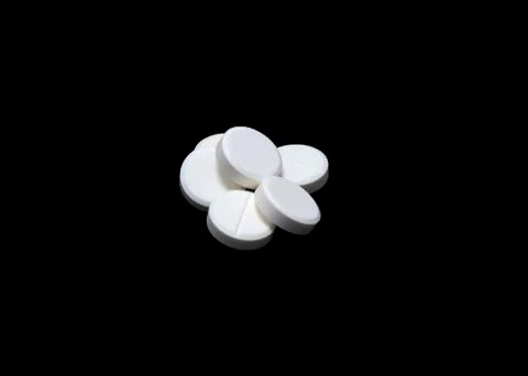 White pills isoltaed on black Stock Photos