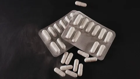 White pills lie on the black background with smoke Stock Footage 127180713