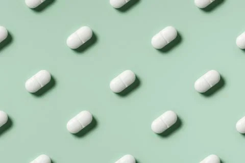 White pills lie in rows diagonal on mint green background top view, pattern Stock Photos