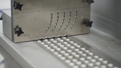 White pills move on automatic line and packaging in inteior of pharma plant. Stock Footage