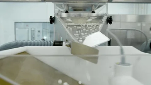 White pills moves on metal automatic line in workshop of pharmaceutical factory Stock Footage 132297581