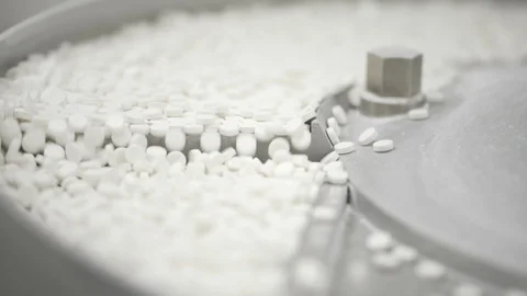 White pills moving on metal automatic line in workshop of pharmaceutical factory Stock Footage