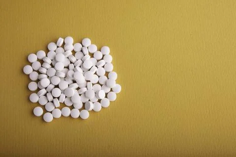 White Pills On Orange Surface Stock-Fotos