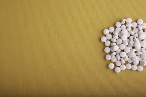 White Pills On Orange Surface Stock Photos