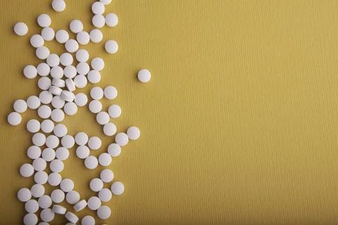 White Pills On Orange Surface Stock Photos