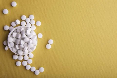 White Pills On Orange Surface 写真素材