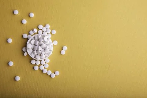 White Pills On Orange Surface Stock Photos