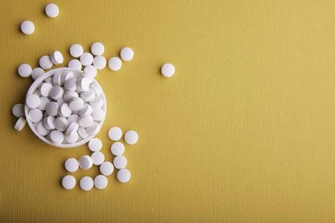White Pills On Orange Surface Stock Photos