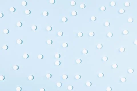 White pills as pattern on soft light blue background in hard light with shado Stock Photos