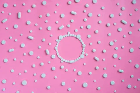 White pills on pink background Stock Photos