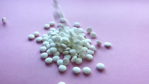 White pills roll on a lilac background. Slow motion, top view. Stock Footage 170451563
