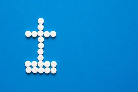 White pills in the shape of a grave cross Stock Photos