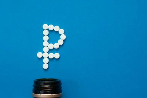 White pills in the shape of a ruble Stock Photos