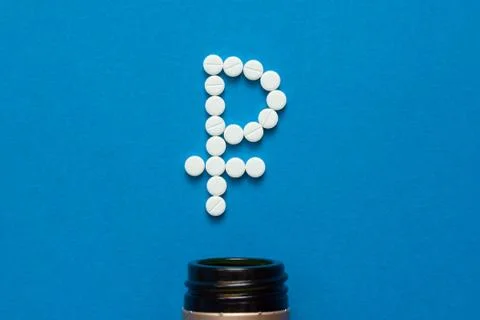 White pills in the shape of a ruble Stock Photos