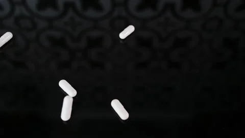 White pills slowly fall down one by one. Concept of addiction to pills, pain Vídeo Stock 262163501