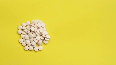 White pills on a yellow background Stock Footage 170124381