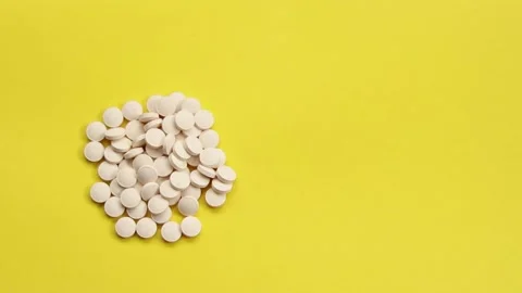 White pills on a yellow background. Stock Footage 170124382
