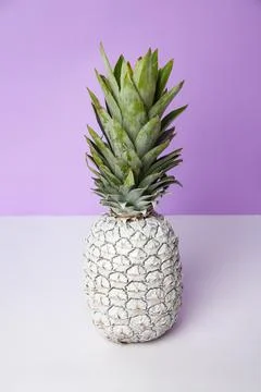 White pineapple on table in studio on violet background Stock Photos
