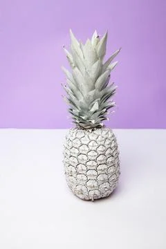 White pineapple on table in studio on violet background Stock Photos