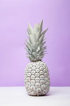 White pineapple on table in studio on violet background Stock Photos