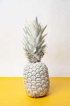 White pineapple on table in studio on white and yellow background Stock Photos