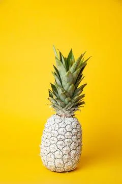 White pineapple on table in studio on yellow background Stock Photos