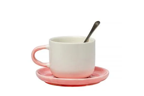 White-pink tea pair with a spoon on a white isolated background. Kitchenware. Stock Photos