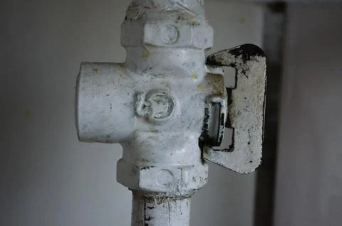 A white pipe with a black bolt on it.  Stock Photos