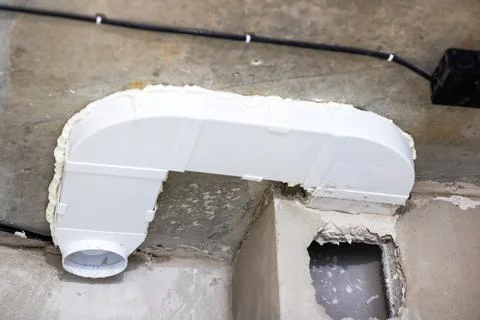A white pipe that has foam on it is securely attached to a wall Stock Photos